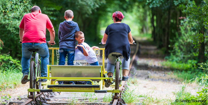 une famille fait une promenade sur un vélo rail.